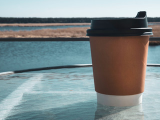 paper cup of coffee background with beautiful view. Film effect