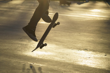 Image of skateboarders' legs and skate. 