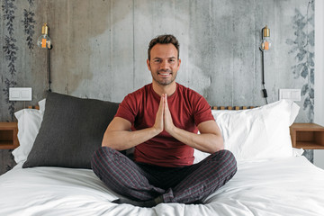 Attractive man on bed meditating