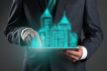 Business presentation of new residential complex. Real estate agent with a tablet computer in hands with building project concept.