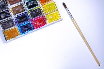 Palette with watercolors and brushes for paints on a white background. Watercolor paints. Brushes. Top and front view