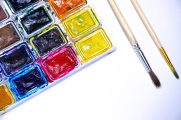 Palette with watercolors and brushes for paints on a white background. Watercolor paints. Brushes. Top and front view