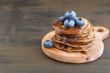Chocolate pancakes with blueberries on a dark background.