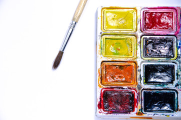 Palette with watercolors and brushes for paints on a white background. Watercolor paints. Brushes. Top and front view