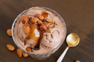 chocolate ice cream in a glass vase. on a wooden background.