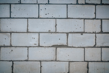 Wall is made from bricks and painted with white color.