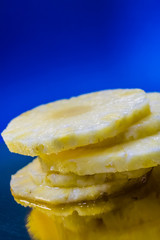 Slices of the fresh and cut pineapple on blue and bright background. Tropical, citrus fruit. A natural product for health. Exotic.