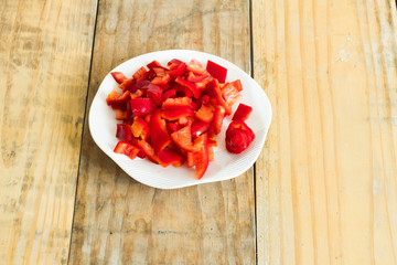  Sliced ​​red pepper on the dirty wooden background with plates