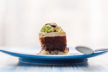 Cake with cream photographed close-up on a blue plate on a wooden background.