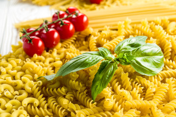 .  curly pasta and basil leaf on the table