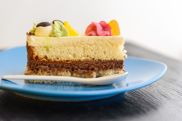 Cake with cream photographed close-up on a blue plate on a wooden background.