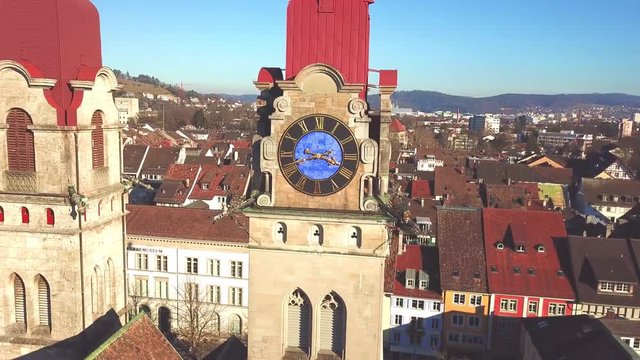 Drone flight with aerial view above church in old town of Winterthur in Switzerland. Tower and building roofs from above. Dynamic, stabilized and smooth shots of European town.