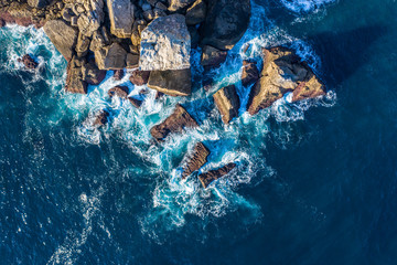 Detail of sea waves colors breaking in the coast of Lekeitio, Basque country - drone aerial view