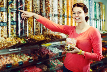 Woman posing to photographer picking different candies