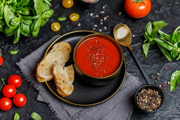 Traditional Spanish cold tomato soup gazpacho in a bowl on stone background. Traditional Spanish food. Concept of Spanish cold soup made of ripe tomatoes. Copy space, closeup