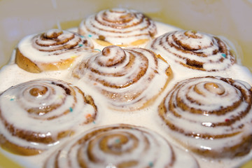 Baked cinnamon buns were poured over with a white icing to soak
