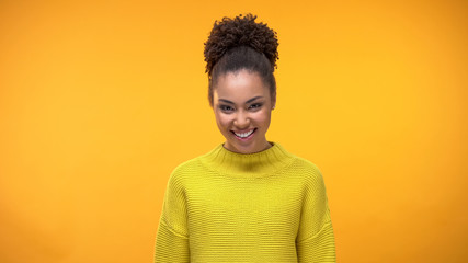 Happy young female in yellow sweater bright background, pretty modern teenager