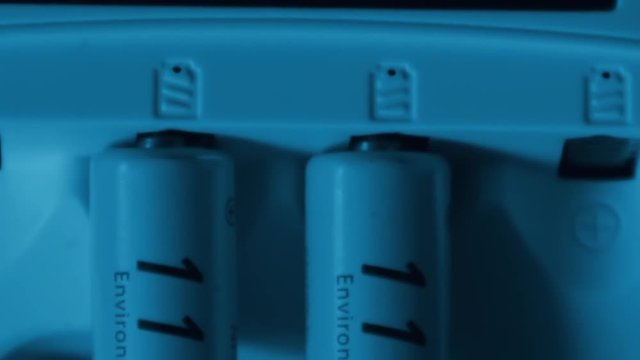 LCD animation shows progress of refilling of rechargeable NiMh batteries in universal multi type battery charger device. Metal hydride accumulators AAA size. Green technology protect environment