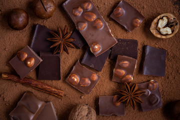 Chocolate, star anise, walnut, macadamia and cocoa powder, dark background, top view.