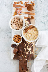 Ingredients for Brownie Balls with Oats, Raw Almonds, Cinnamon, Salt, Dates, and Cocoa on Cutting Board
