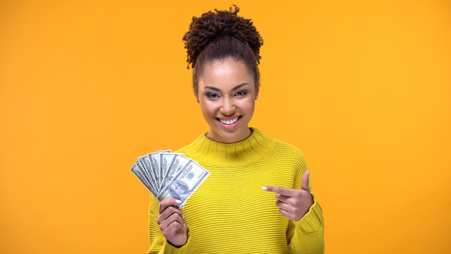 Smiling Young Lady Pointing At Dollar Banknotes In Hand, Bank Credit, Earnings