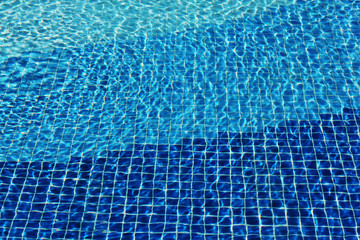 Swimming pool mosaic bottom caustics ripple like sea water. Flow with waves, sport and relax concept. Summer background. Texture of water surface. Top view. water waves with