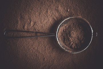 Cocoa powder in a sieve, top view.