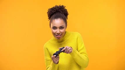 Young african-american woman playing video games with game controller, fun