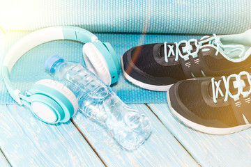 Yoga Mat, sports shoes, water bottle on blue background concept of healthy living, healthy eating, sports and diet