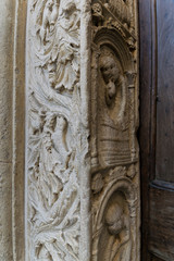 Fototapeta na wymiar Detail of a medieval door carvings outside an italian cathedral
