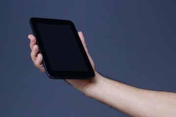 Hand holding tablet with clear screen at isolated background