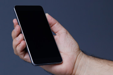 Hand holding cellphone with clear screen at isolated background