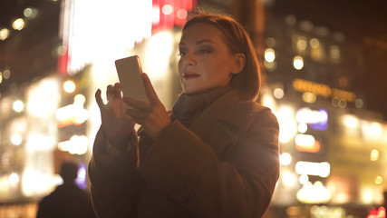 Lady booking plane or bus tickets online, standing on illuminated background