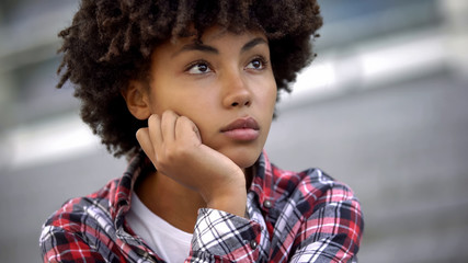 Pensive afro-american teenager thinking about future plans, choosing profession