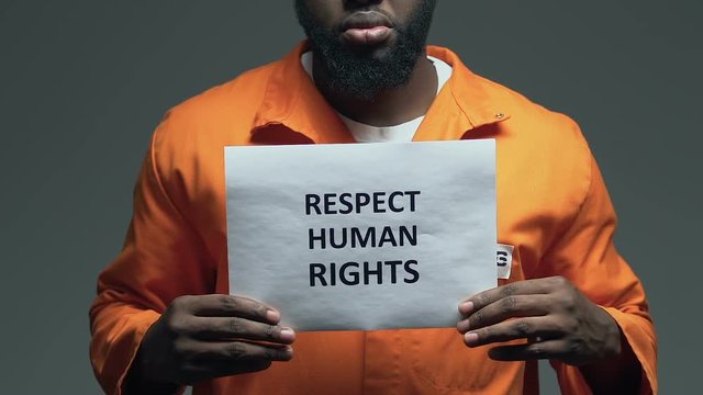Respect human rights phrase on cardboard in hands of Afro-American prisoner
