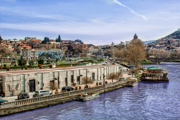 View of the Kura River from the Peace Bridge on Europe Square, Tbilisi. Georgia. Beautiful landscape. 