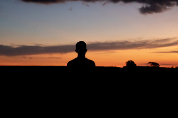 Man watching sunset with silhouette arches in summer