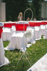 Element of wedding decor. Wedding chairs for guests decorated with ribbons.