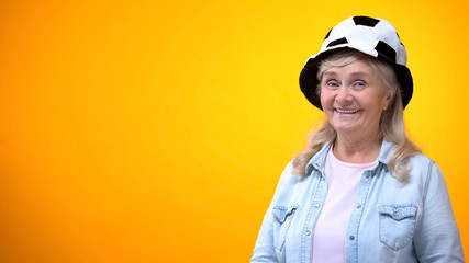 Smiling old woman wearing funny football hat, template for ad, sport betting