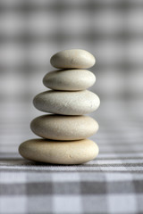 Fototapeta na wymiar Harmony and balance, cairns, simple poise stones on white gray checkered background, rock zen sculpture, five white pebbles
