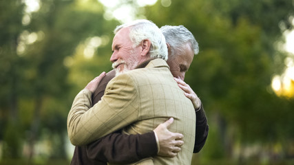 Mature men hugging, happy to see each other, old friends meeting, greeting