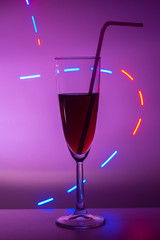 glass of cocktail with background.  A glass on the bar in a cafe, restaurant, nightclub or disco. Glass or stemware with alcohol or a cocktail on a colored background.