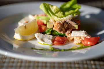 Salad with avocado and grilled salmon in Cafe
