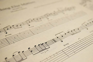 notes of the song for playing the guitar with tablature on the yellowed paper