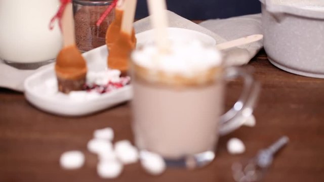 Salted caramel hot cocoa spoon in glass cup.