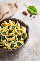 Conchiglioni pasta with spinach in creamy sauce