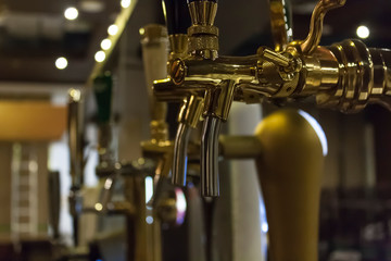 close-up of golden beer taps in a nightclub / bar / pub