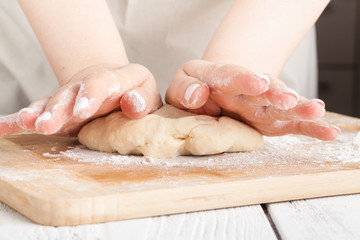 Obraz na płótnie Canvas hands making dough on kitchen, close up view