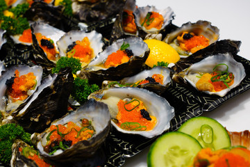 Dish of oysters stuffed with black and orange caviar
