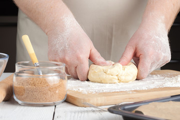 Fototapeta premium cooking and home concept - close up of hands making cookies from fresh dough at home